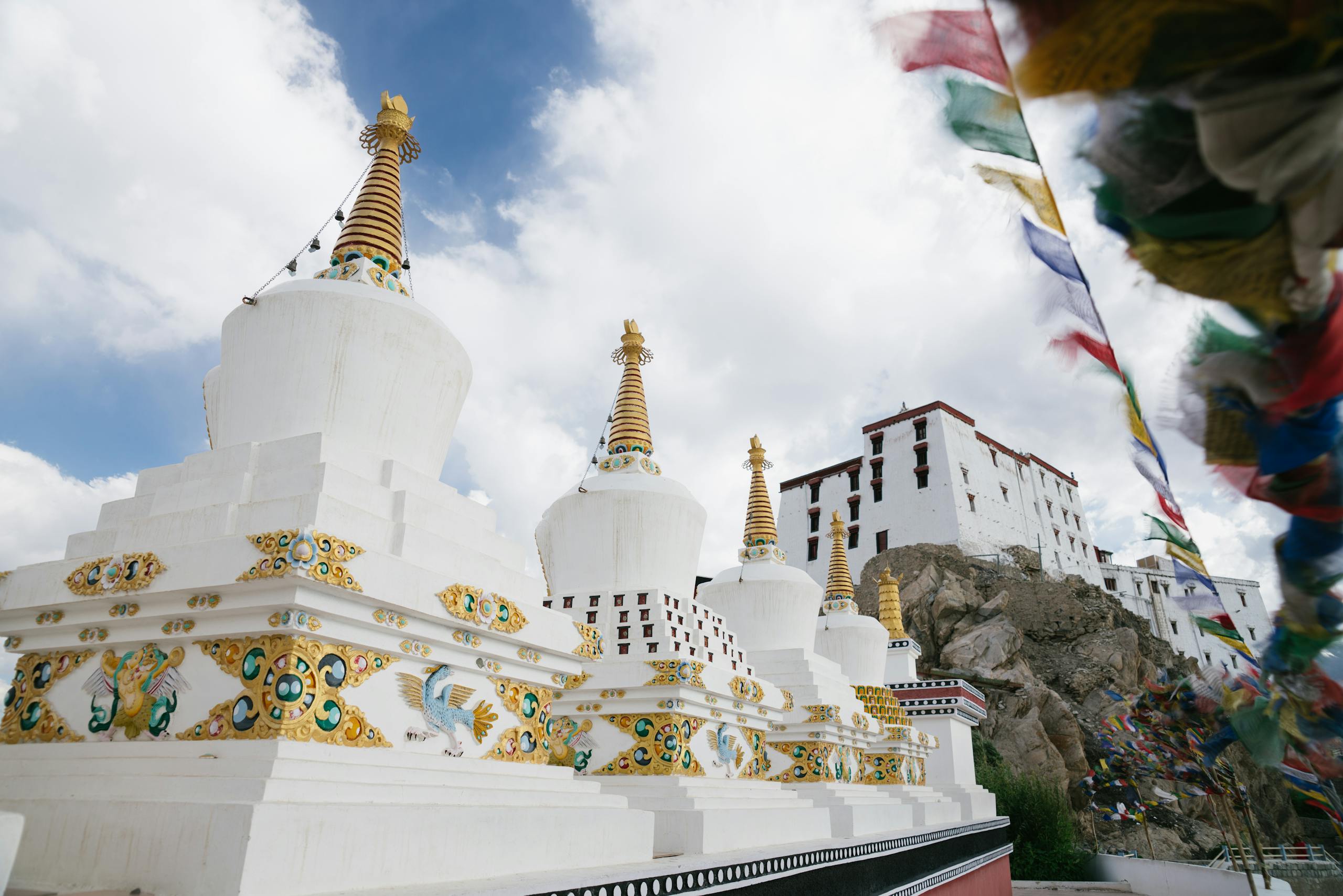 Beautiful view of Thiksey Monastery with white stupas under a bright sky in Ladakh, India.