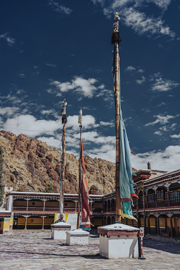 Vibrant prayer flags in the courtyard of Hemis Monastery, India with mountain backdrop.